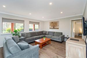 a living room with two couches and a table at Banksia Tourist Park in Perth