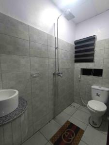 uma casa de banho com um chuveiro, um WC e um lavatório. em Dabb Apartments em Ilorin