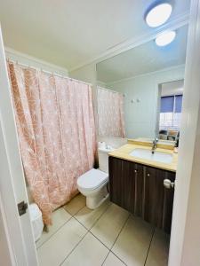 a bathroom with a toilet and a sink and a mirror at Apartamento vista al mar in Iquique