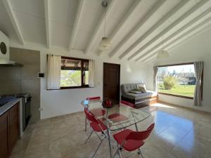 - un salon avec une table en verre et des chaises rouges dans l'établissement Viento y montaña, à San Carlos de Bariloche