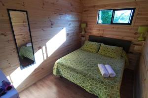 1 dormitorio con 1 cama en una cabaña de madera en Alojamiento turístico WiFi, en Panguipulli