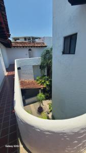 a balcony of a building with a table and palm trees at small villa in the marina in Puerto Vallarta