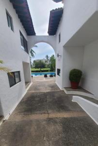 an archway in a white building with a pool at small villa in the marina in Puerto Vallarta