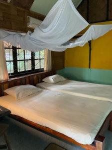 two beds in a room with a mosquito net at Dawn of Happiness in Ao Nam Mao