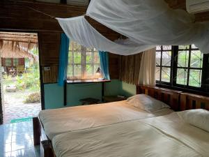 een slaapkamer met twee bedden met klamboes erboven bij Dawn of Happiness in Ao Nam Mao