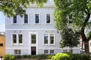 una casa bianca con un albero davanti di Cork Factory Richmond a Melbourne