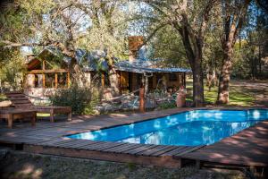 a house with a wooden deck and a swimming pool at GLAMPING TICA NATIVO in Villa Carlos Paz