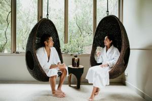 a man and a woman sitting in circular chairs in a room at Peninsula Hot Springs in Fingal