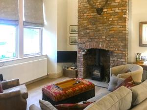 a living room with couches and a brick fireplace at Harrow House in Berwick-Upon-Tweed