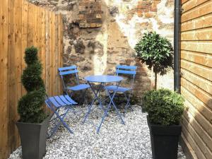 a table and two chairs and two potted plants at Harrow House in Berwick-Upon-Tweed