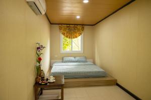 a small bedroom with a bed and a window at Halo Retreat in Hòa Bình