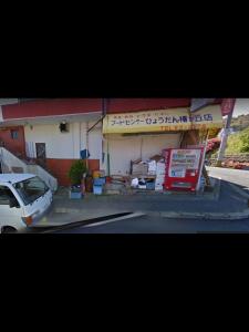 um carro branco estacionado em frente a um edifício em Ochihime no Yado / Vacation STAY 7615 em Nagasaki