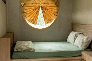 małe łóżko w pokoju z oknem w obiekcie Halo Retreat w mieście Hòa Bình