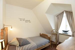 een kleine slaapkamer met een bed en een raam bij Ferienhaus-Hoppe-Wohnung-01 in Westerland