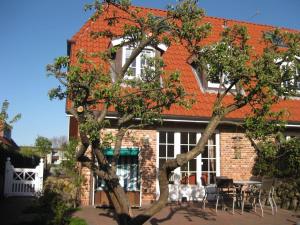 een gebouw met een boom ervoor bij Ferienhaus-Hoppe-Wohnung-01 in Westerland