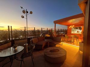a rooftop patio with a view of the city at sunset at Unique Mine Luxury SMART LOFTS in Bogotá