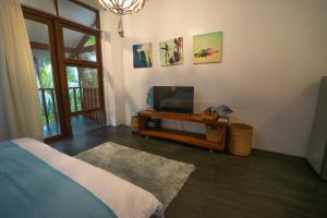 a bedroom with a tv and a table with a television at Villa Cali Siargao in General Luna