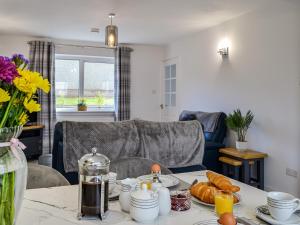 un soggiorno con tavolo e cibo sopra di Anchor Cottage a Portpatrick