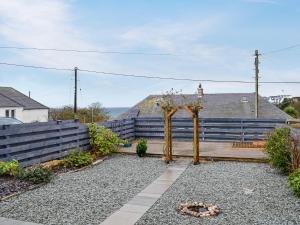 un jardín con un arco de madera y escaleras en Anchor Cottage, en Portpatrick