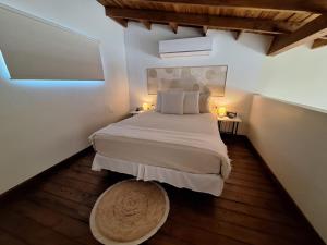 a bedroom with a bed with two lamps and a rug at Anaté Beach Apartments, Mangel Alto in Savaneta