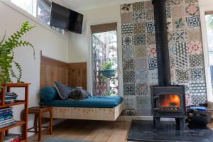 a cat laying on a couch in a living room with a fireplace at Bellshala bungalow in Bellbrae