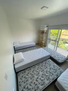 En eller flere senge i et værelse på Casa na Praia da Ferrugem com 2 vagas