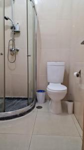 a bathroom with a toilet and a glass shower at Casa de férias com 2 quartos ou aluguer diária in Praia