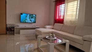 a living room with a couch and a tv at Casa de férias com 2 quartos ou aluguer diária in Praia