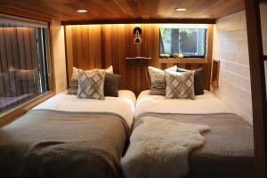 two beds in a room with wooden walls at サウナ・ジャグジー・完全貸し切りという贅沢　大人の秘密基地　Tiny Cabin TATEGU#02 in Miyota