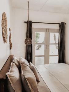 a bedroom with a bed with pillows and a window at Mermaid Beach in Ahangama