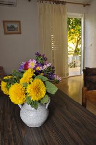 a vase filled with colorful flowers sitting on a table at Apartments Mama in Rab
