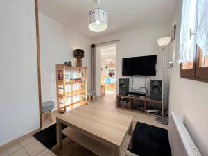 Il comprend un salon doté d'une table et d'une télévision à écran plat. dans l'établissement Appartement cosy pour 4 pers, 400m pistes et village, balcon, parking et casier à skis, La Salle-les-Alpes - FR-1-330F-221, à La Salle Les Alpes