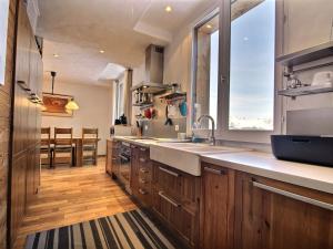a kitchen with wooden cabinets and a large window at Chalet Plagne 1800, 6 pièces, 12 personnes - FR-1-455-238 in La Plagne Tarentaise