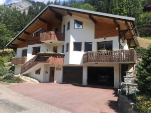 a large house with a balcony and a driveway at Appartement charmant rénové avec jardin, garage et Wifi - FR-1-692-91 in La Chapelle-dʼAbondance