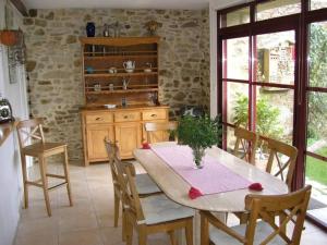 uma sala de jantar com uma mesa e cadeiras numa cozinha em Gîte La Chapelle-des-Marais, 2 pièces, 4 personnes - FR-1-306-1258 em La Chapelle-des-Marais
