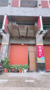 um edifício com uma porta vermelha e algumas plantas em Feng Jing Yuan em Pingtung