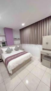 a bedroom with a large bed and a television at Feng Jing Yuan in Pingtung City