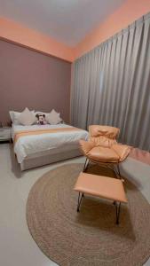a bedroom with a bed and a chair and a rug at Feng Jing Yuan in Pingtung City