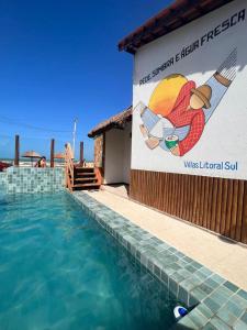 a swimming pool with a sign on the side of a building at Flats Villas Litoral Sul - Praia Pontal do Peba - Piaçabuçu - AL in Piaçabuçu