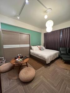 um quarto com uma cama, uma mesa e uma cadeira em Feng Jing Yuan em Pingtung