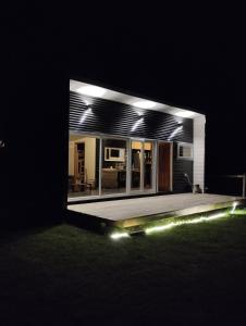 a house with lights on the grass at night at Cabaña / loft in Puerto Montt