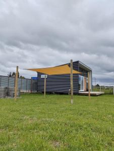 una pequeña casa con techo amarillo en un campo en Cabaña / loft, en Puerto Montt