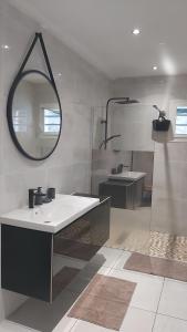 een badkamer met een wastafel en een spiegel bij Lala location Le Moule in Le Moule