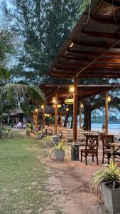 a wooden pavilion with benches and tables in a park at Lanta Villa Resort in Ban Ai Dao