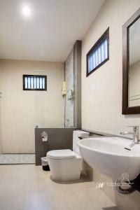 a bathroom with a white toilet and a sink at Lanta Villa Resort in Ban Ai Dao