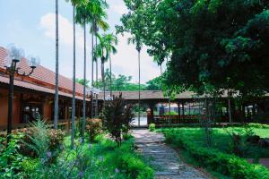 a garden in front of a building with palm trees at Spatel d'Annam - Imperial Boutique Spa & Hotel in Hue +44 photos