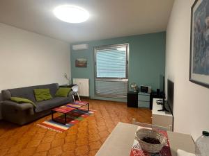 Una sala de estar con un sofá y un televisor. en AURORA GARGEN IN CENTRO, en Trieste