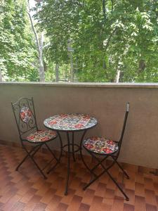 two chairs and a table on a porch at AURORA GARGEN IN CENTRO in Trieste
