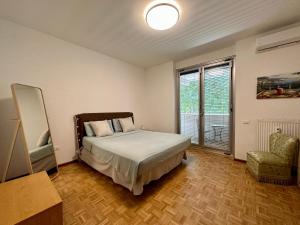 a bedroom with a bed and a chair and a window at AURORA GARGEN IN CENTRO in Trieste