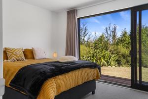 漢默溫泉的住宿－Ridge Retreat - Hanmer Springs Holiday Home，一间卧室设有一张床和一个大窗户